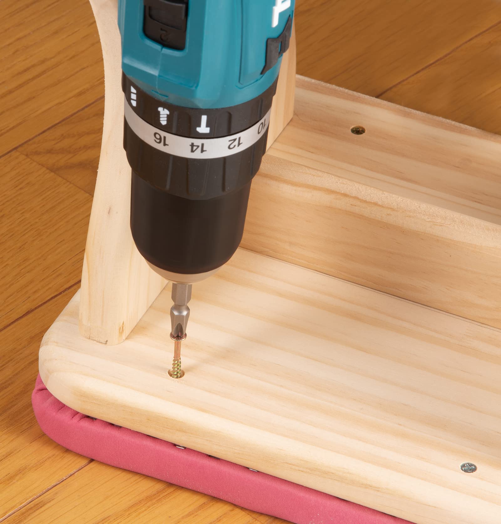 Drill bit being used on a wooden surface with a drill